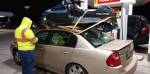 Человек привязывает снегоход к крыше своего Chevy Malibu 2005 года